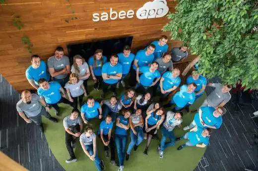 El equipo de SabeeApp reunido bajo el logotipo de la oficina en Budapest