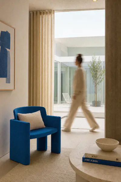 Blurred figure walking past a blue armchair in a boutique hotel lounge