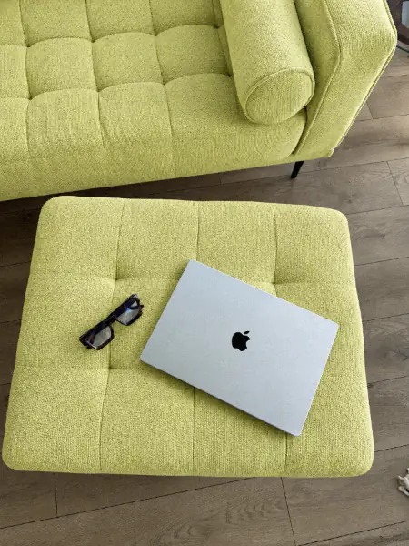 Laptop and glasses on a lime boucle ottoman