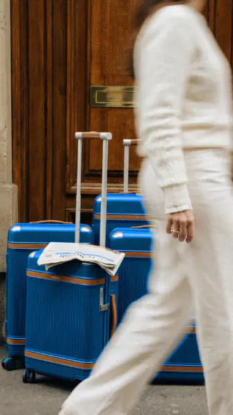 Suitcases outside a hotel entrance as a guest walks past