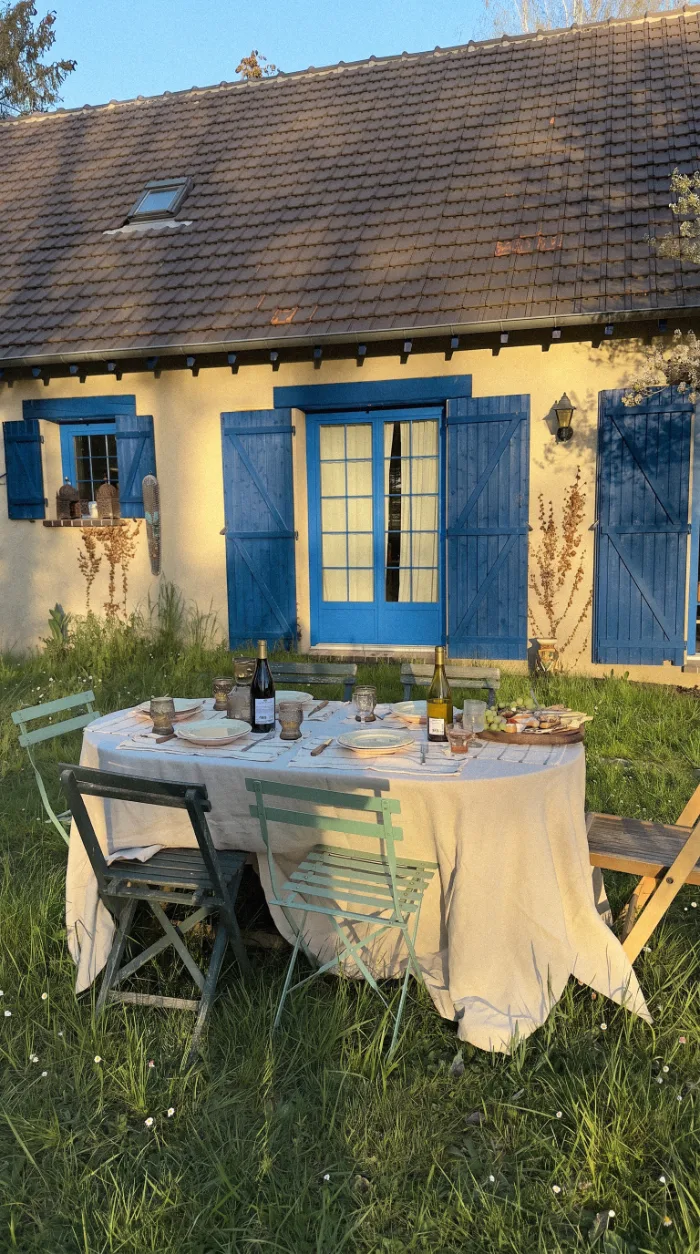 Garden table outside a cottage with blue shutters
