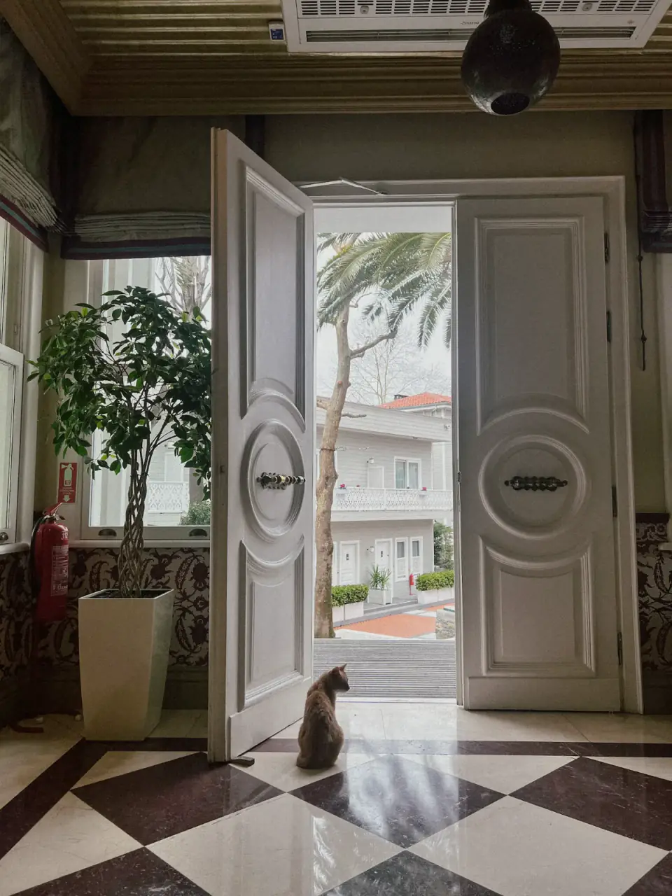 Hotel lobby with open double doors onto a garden entrance