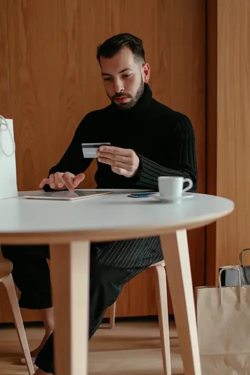 man_sitting_at_table_buying_online-1