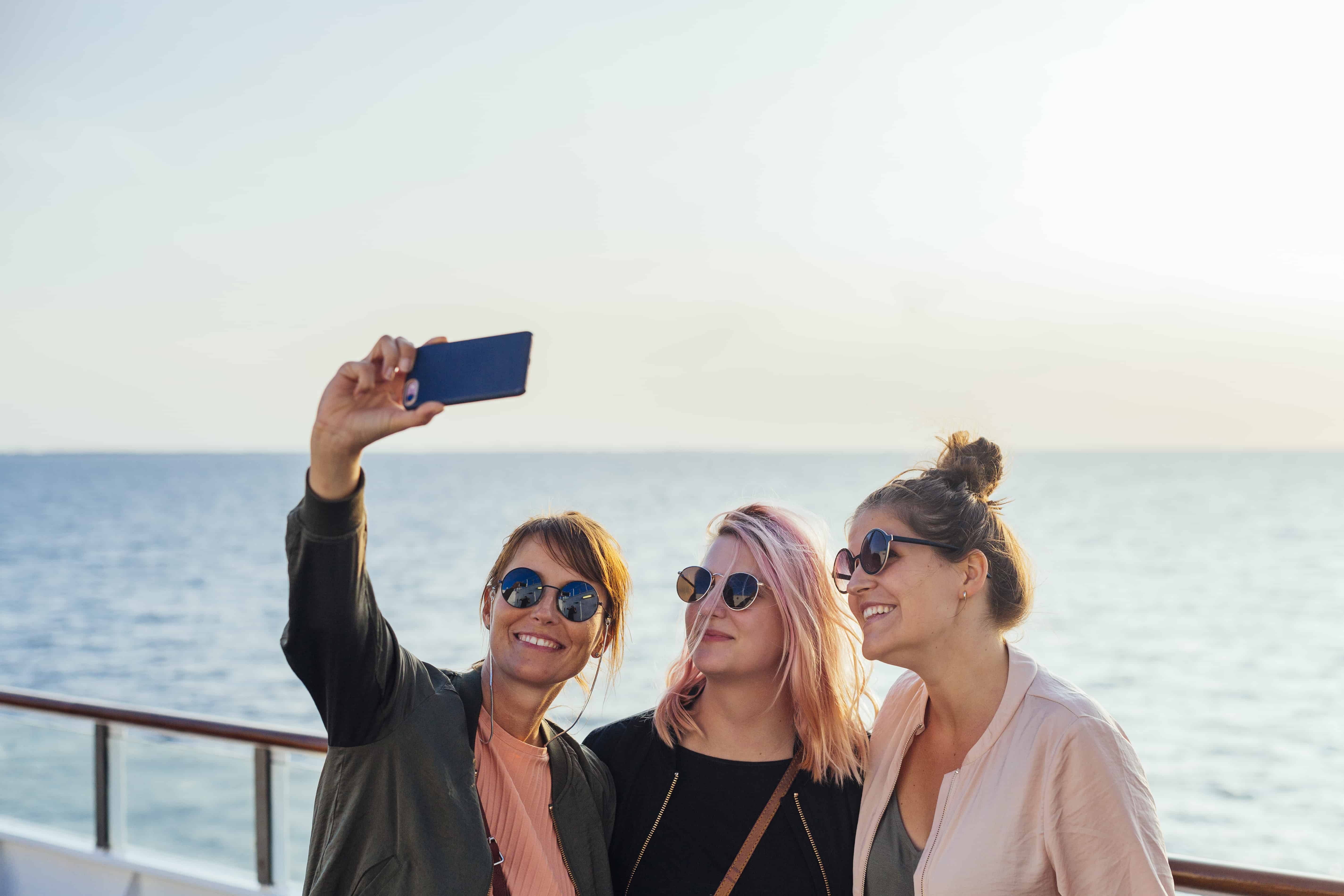 three-women-taking-selfie-on-ship-deck-2024-10-17-14-42-54-utc-min