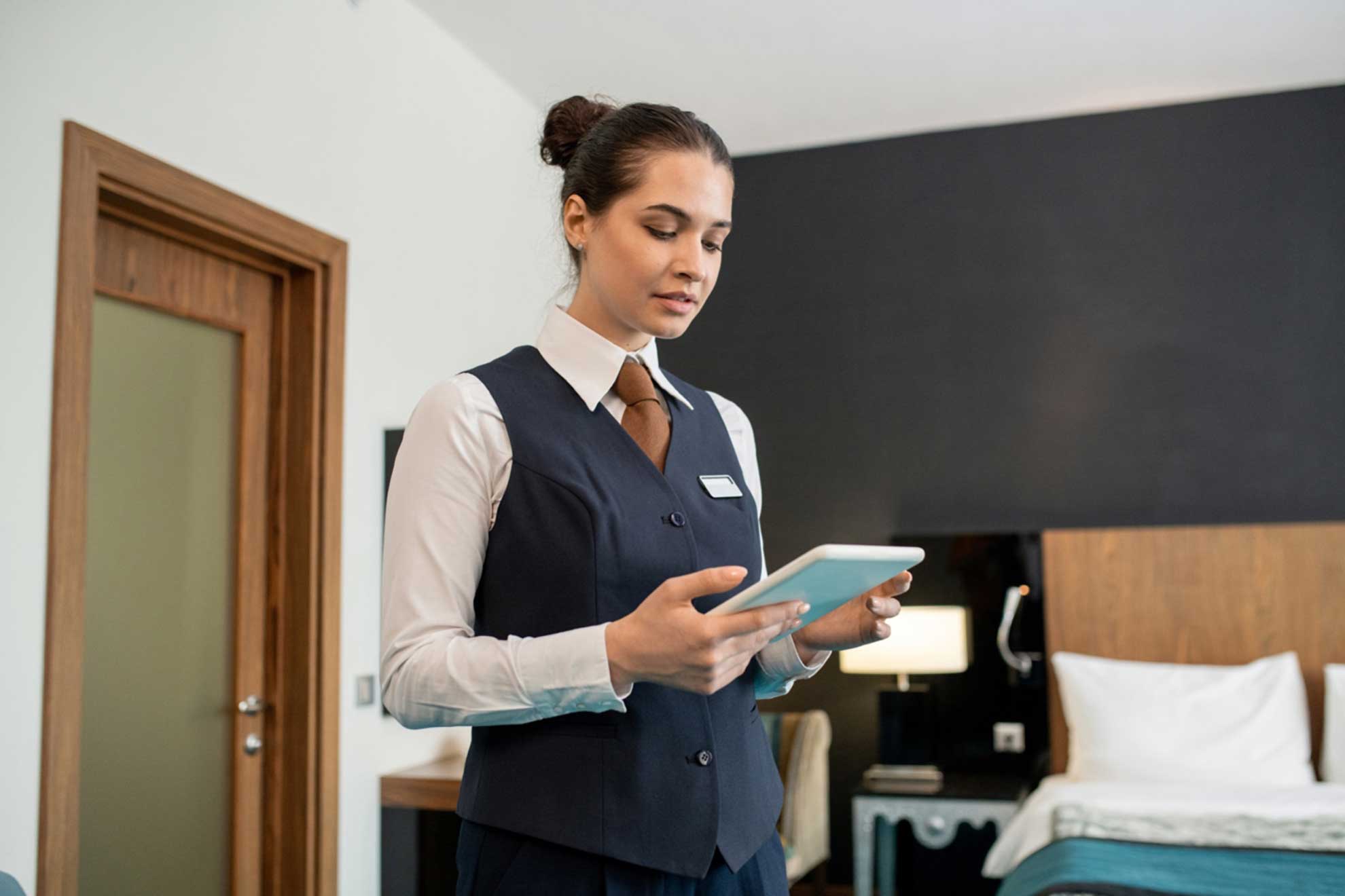 young-hotel-worker-uniform-using-tablet-bedroom