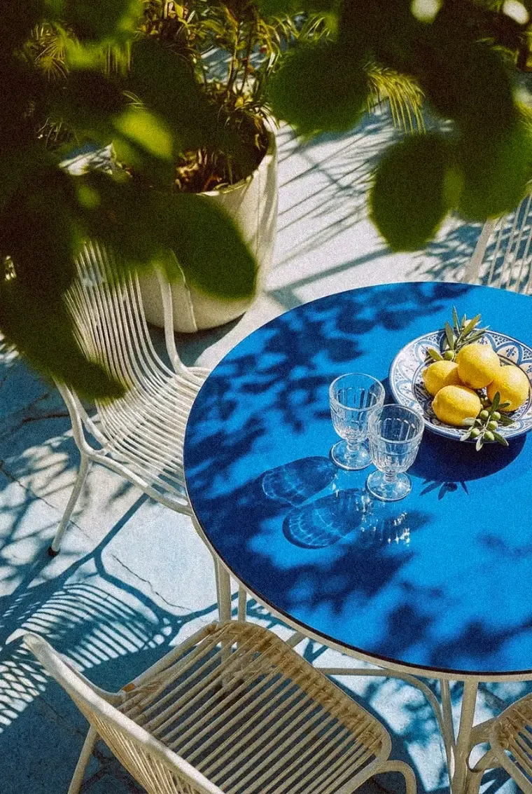 Sunlit hotel terrace table with lemons and glassware